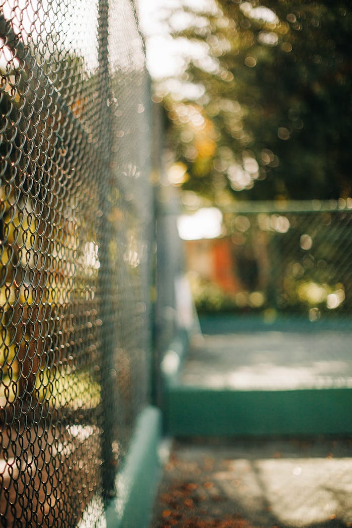 Close-up of an outdoor chain link fence with a beautiful bokeh effect in the background.